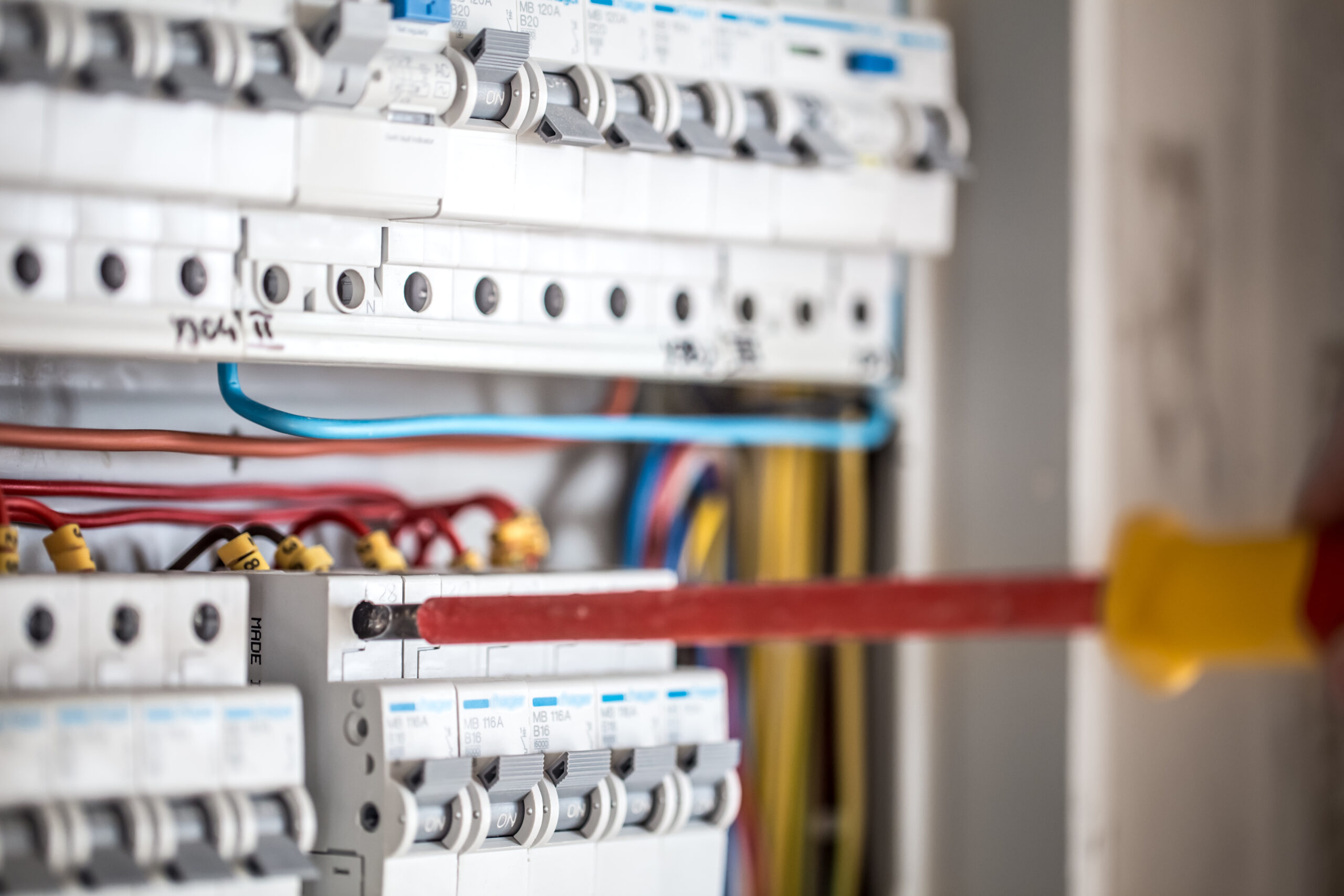 Homme technicien electricien travaillant dans un tableau avec fusibles installation et connexion d equipements electriques fermer
